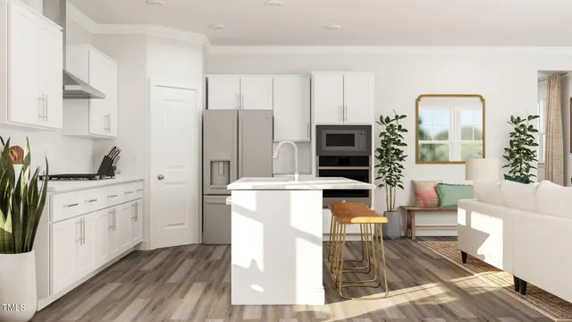 a kitchen with stainless steel appliances kitchen island granite countertop a refrigerator stove oven and white cabinets with wooden floor