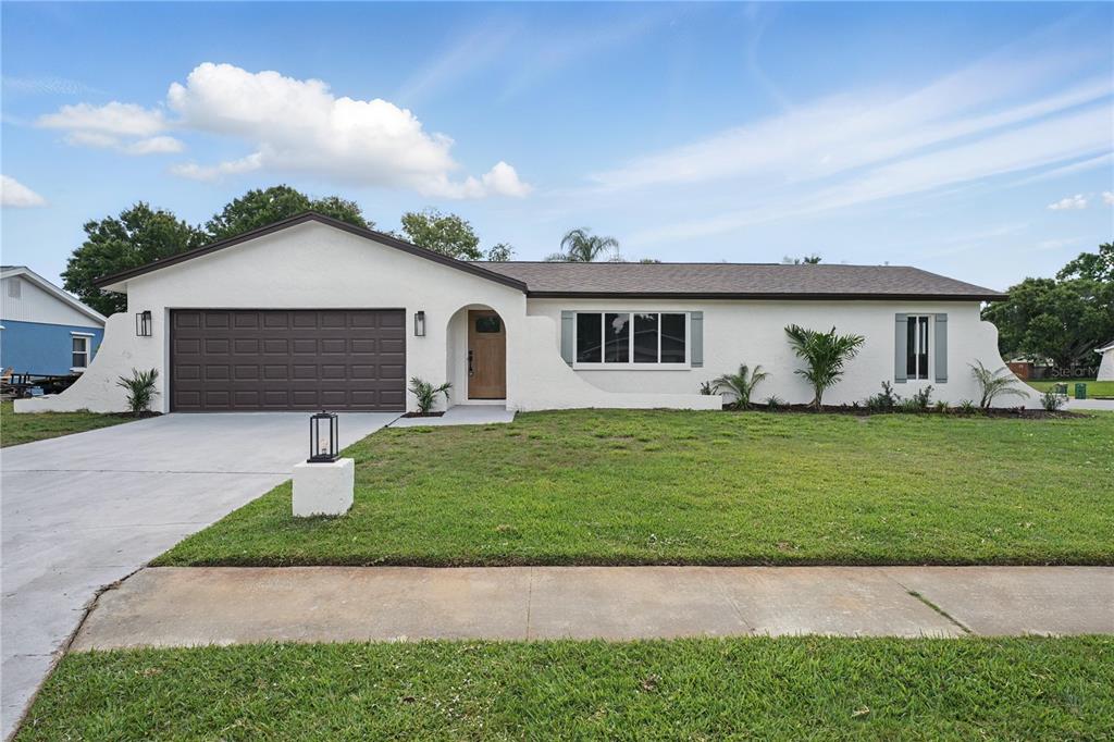 a front view of a house with a garden and yard