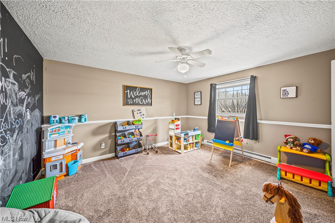 7290 Turner Road Pierpont, OH 44082 - Photo 25 of 36 Rec room featuring carpet, baseboard heating, a textured ceiling, and ceiling fan