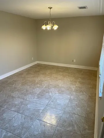 a view of a room with a chandelier fan and fire place