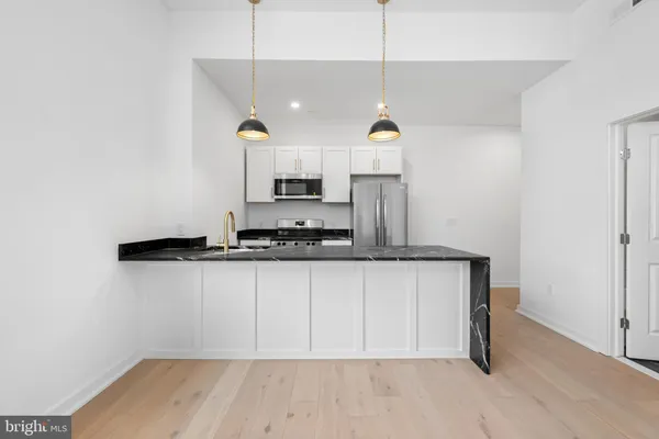 a kitchen with a sink cabinets and wooden floor