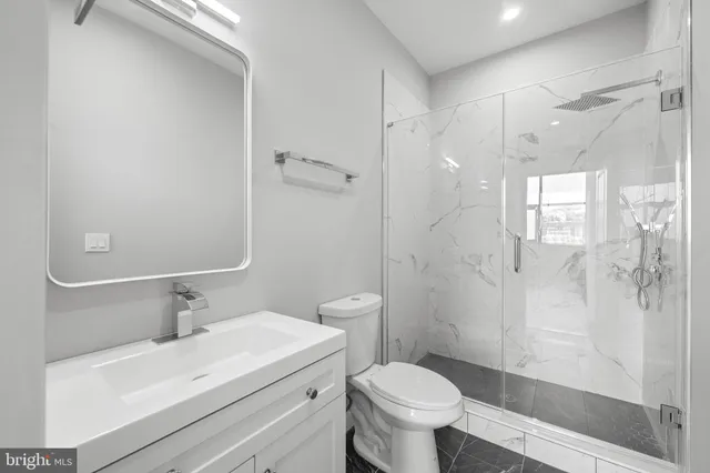 a bathroom with a toilet sink vanity and shower