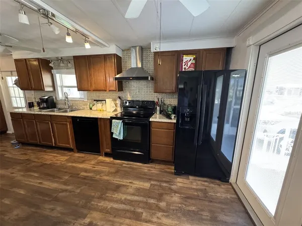 a kitchen with kitchen island granite countertop lots of counter top space a sink and stainless steel appliances