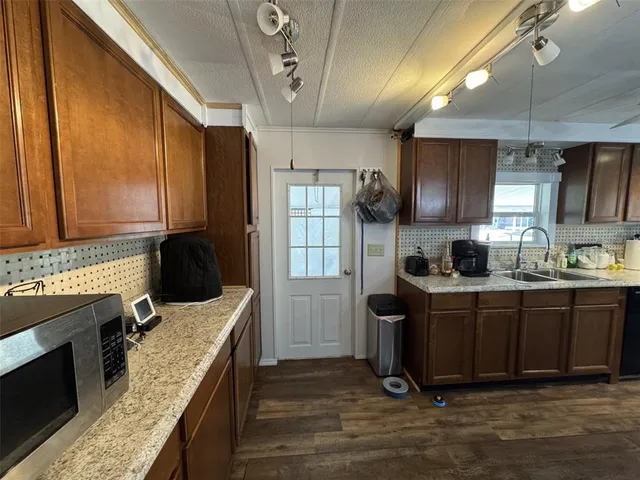 a kitchen with a dining table chairs and refrigerator