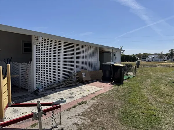 a view of backyard with seating space and wooden fence