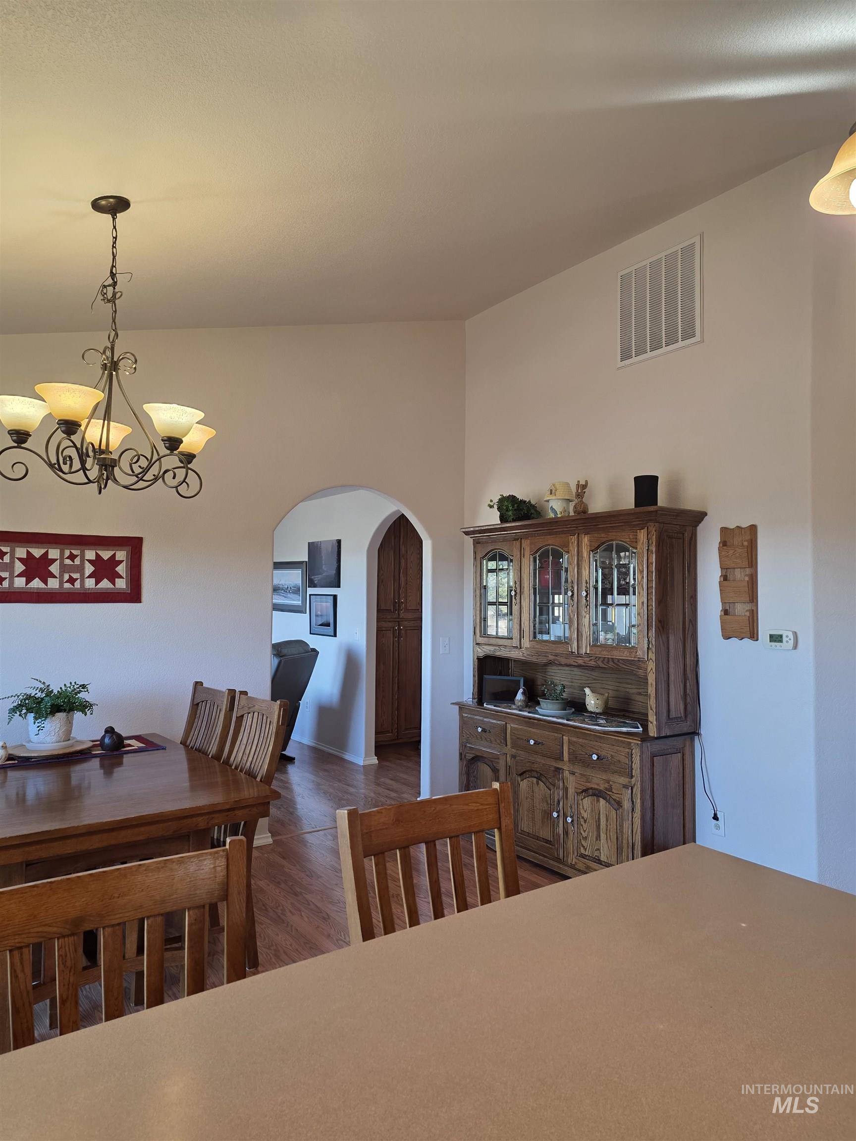 5288 Lakeview Road Orofino, ID 83544 - Photo 14 of 36 Dining space with arched walkways, suspended lighting, and dark wood-style floors