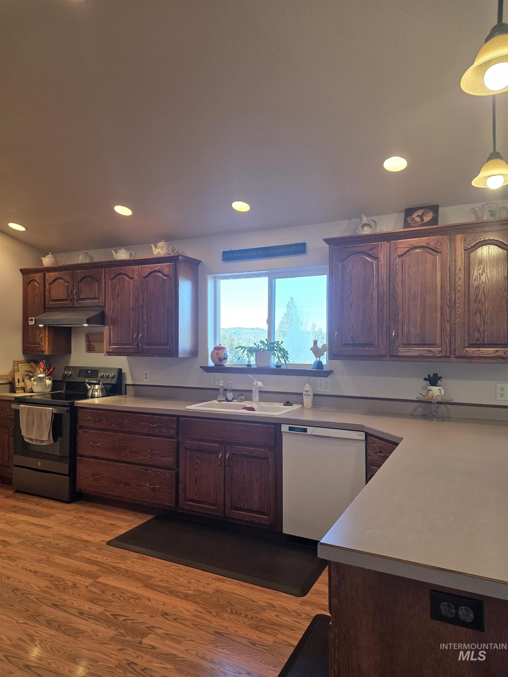 5288 Lakeview Road Orofino, ID 83544 - Photo 16 of 36 Kitchen with electric stove, light countertops, white dishwasher, and light wood-type flooring