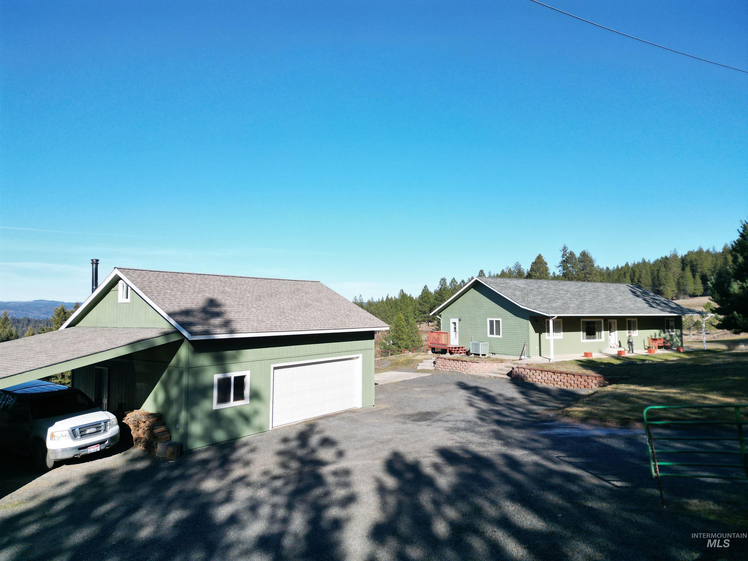 5288 Lakeview Road Orofino, ID 83544 - Photo 2 of 36 View of front facade with a garage, an outbuilding, a shingled roof, a porch, and driveway