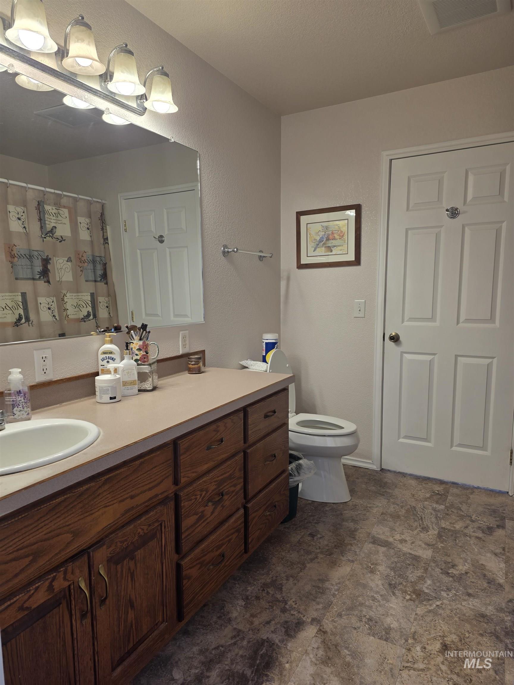 5288 Lakeview Road Orofino, ID 83544 - Photo 22 of 36 Full bath with vanity, a shower with curtain, a textured wall, and stone finish floors