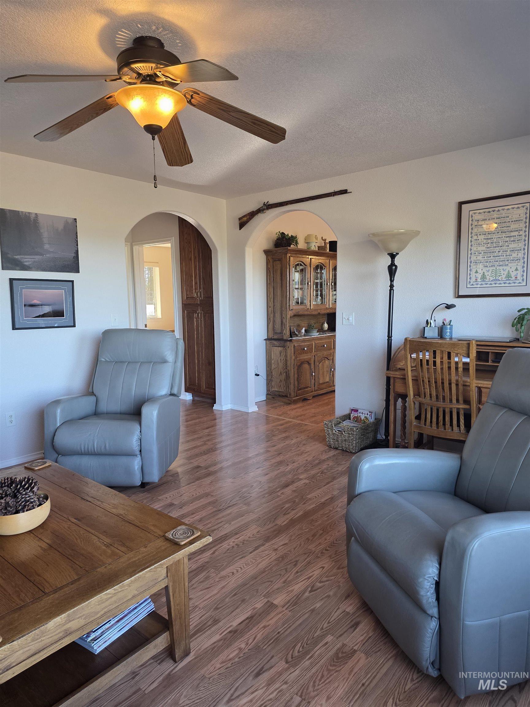 5288 Lakeview Road Orofino, ID 83544 - Photo 32 of 36 Living area with ceiling fan, wood finished floors, a textured ceiling, and arched walkways