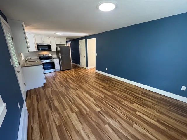 a view of a kitchen with wooden floor and electronic appliances