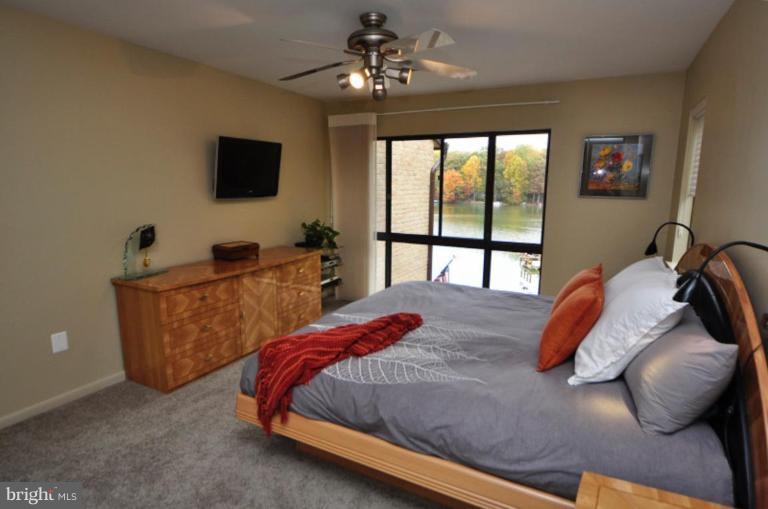 11322 Dockside Circle Reston, VA 20191 - Photo 2 of 22 a bedroom with a large bed and a flat tv screen
