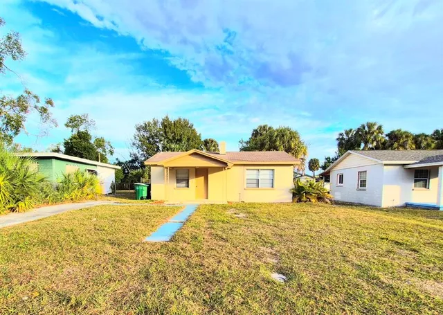 a blue swimming pool is in front of the house