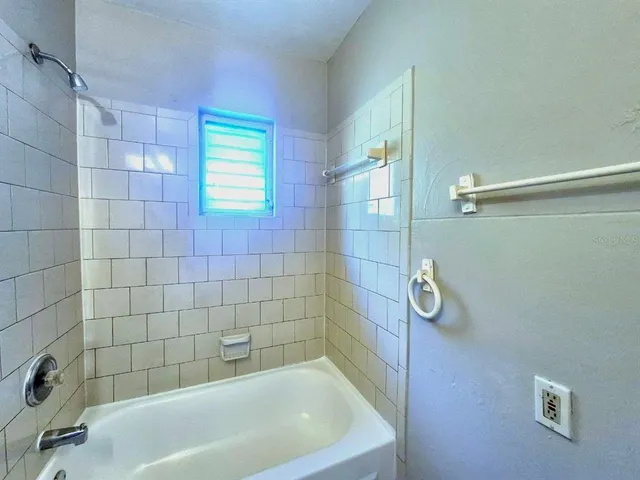 a bath tub sitting in a bathroom next to a window