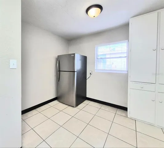 a view of a refrigerator in kitchen and a window