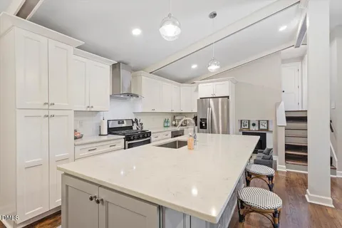 a kitchen with kitchen island a stove a table and chairs in it
