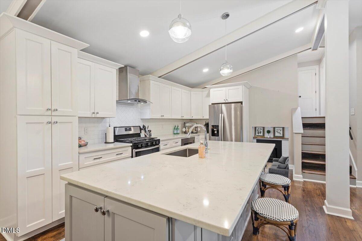 2120 Hillock Drive Raleigh, NC 27612 - Photo 15 of 29 a kitchen with kitchen island a stove a table and chairs in it