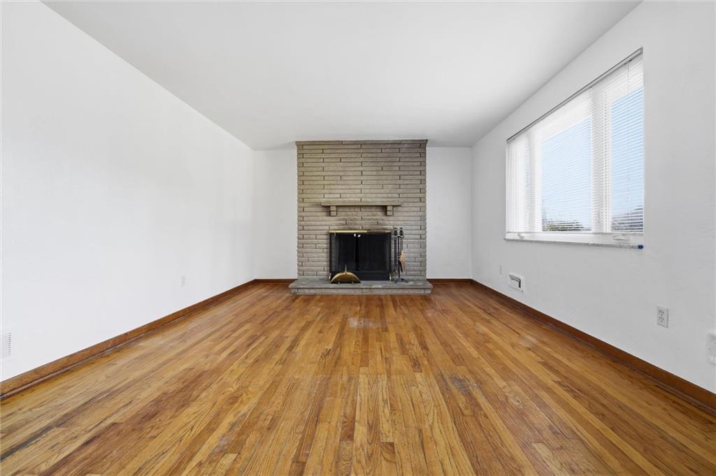 2055 Washington Road Pittsburgh, PA 15241 - Photo 7 of 31 an empty room with wooden floor fireplace and windows
