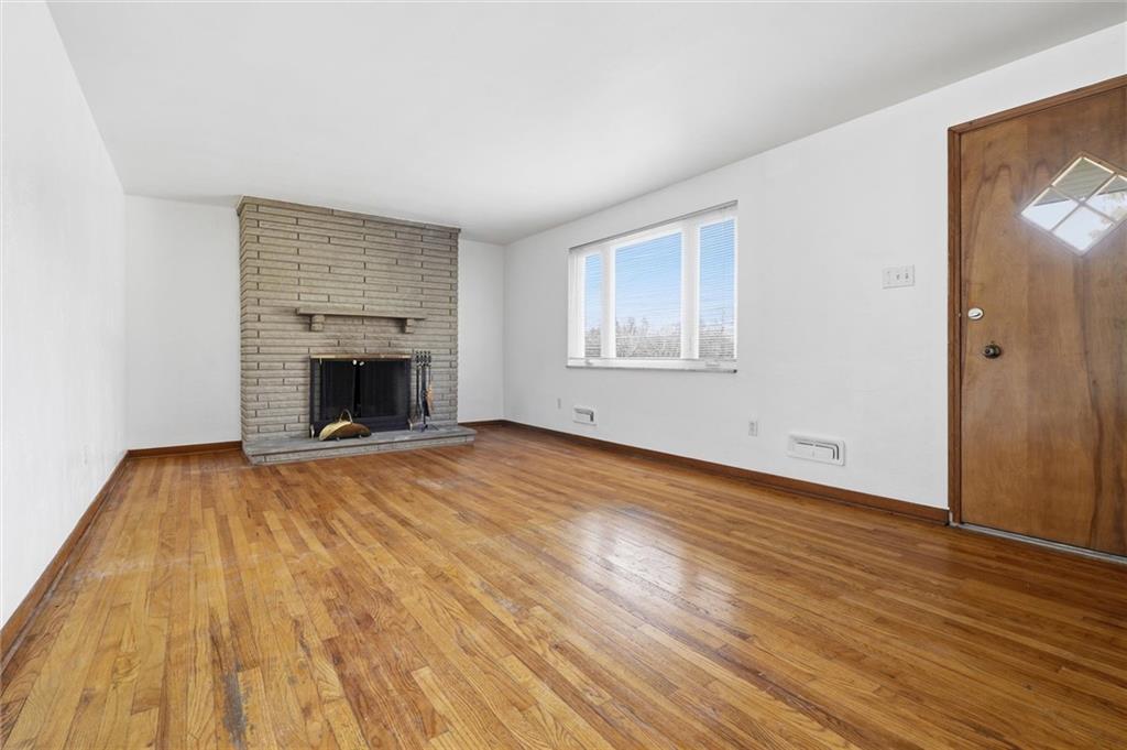 2055 Washington Road Pittsburgh, PA 15241 - Photo 8 of 31 an empty room with wooden floor and a fireplace