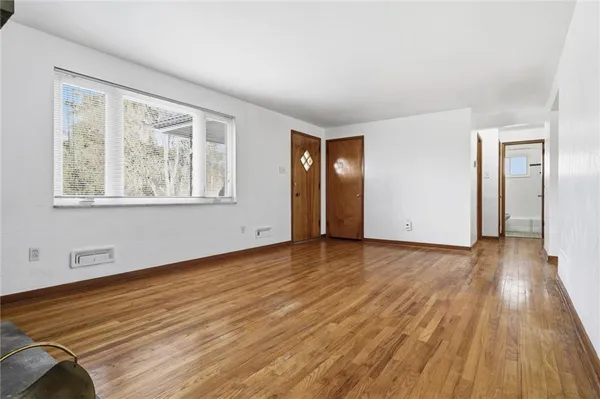 wooden floor in an empty room with a window