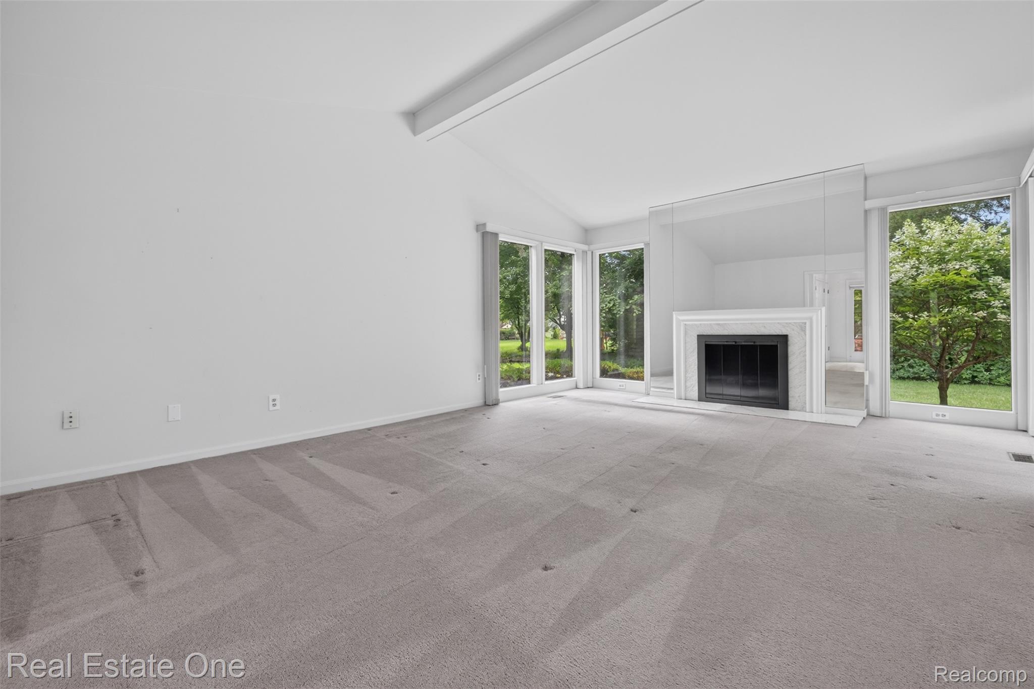 3400 Wedgewood Drive Rochester, MI 48306 - Photo 9 of 49 Vaulted ceiling living space featuring a fireplace with a decorative mantel and hearth, flanked by expansive windows