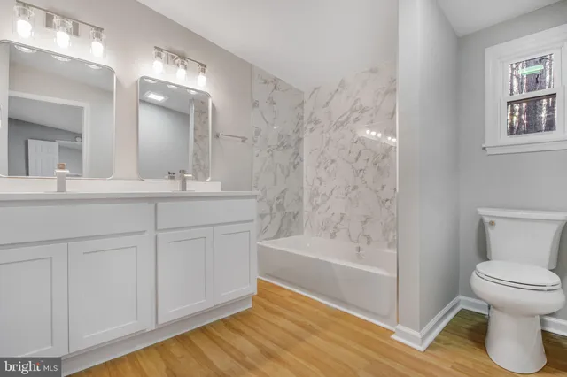 a bathroom with a tub sink and mirror