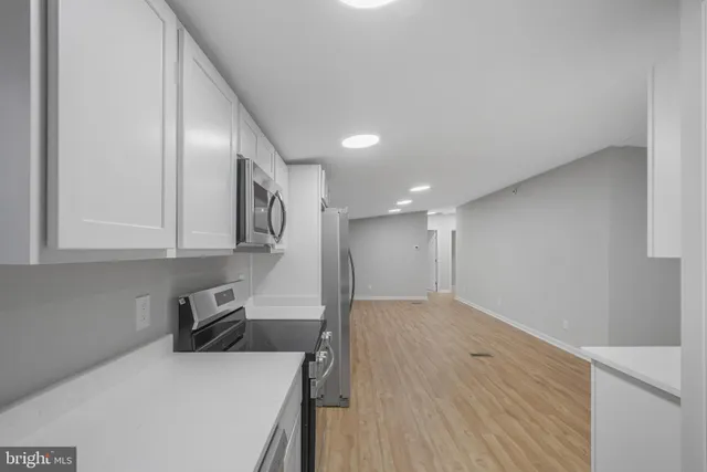 a kitchen with a refrigerator sink and cabinets