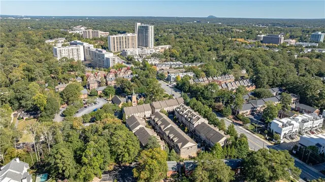 an aerial view of a residential houses with outdoor space and trees