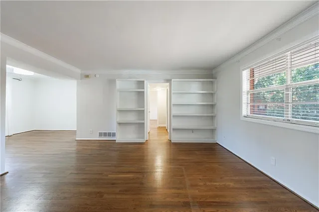 a view of a room with wooden floor and a window
