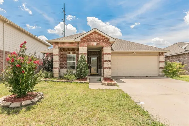 a view of a house with potted plants and a yard