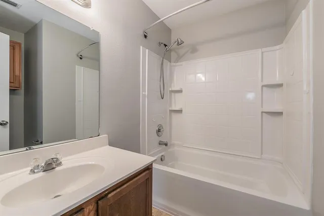 a bathroom with a tub sink shower and a mirror