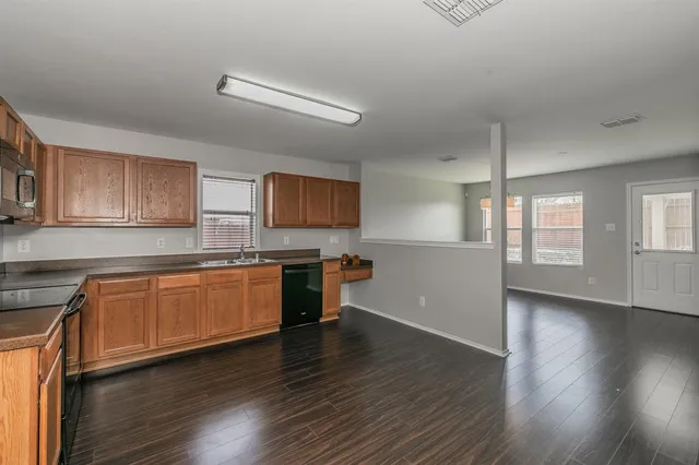 a kitchen with granite countertop wooden floors and stainless steel appliances