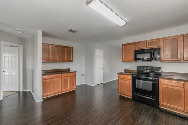 a kitchen with stainless steel appliances granite countertop a stove top oven a sink and a microwave