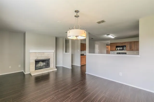 a view of a kitchen with a sink a fireplace and wooden floor