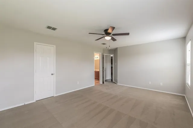 a view of an empty room with a chandelier fan
