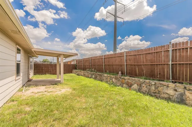 a view of backyard with wooden fence