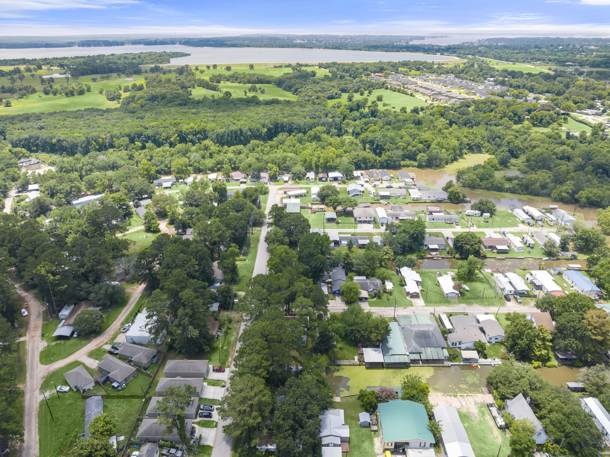 9649 Warm Spring Willis, TX 77318 - Photo 27 of 30 An aerial perspective reveals a vibrant neighborhood with ample green space and nearby water features.
