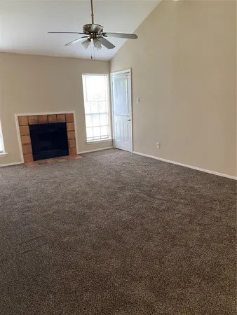 en empty room with windows and chandelier fan