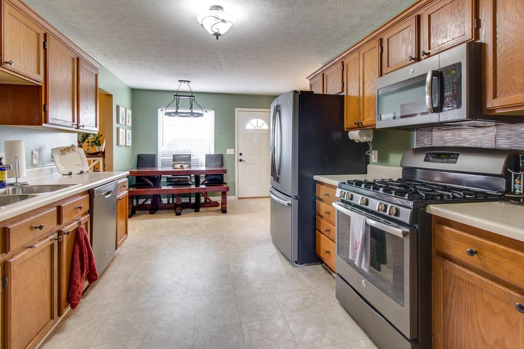 392 Cedar Grove Road Lebanon, TN 37087 - Photo 9 of 28 a kitchen with stainless steel appliances granite countertop a stove top oven a sink dishwasher a refrigerator and cabinets with wooden floor