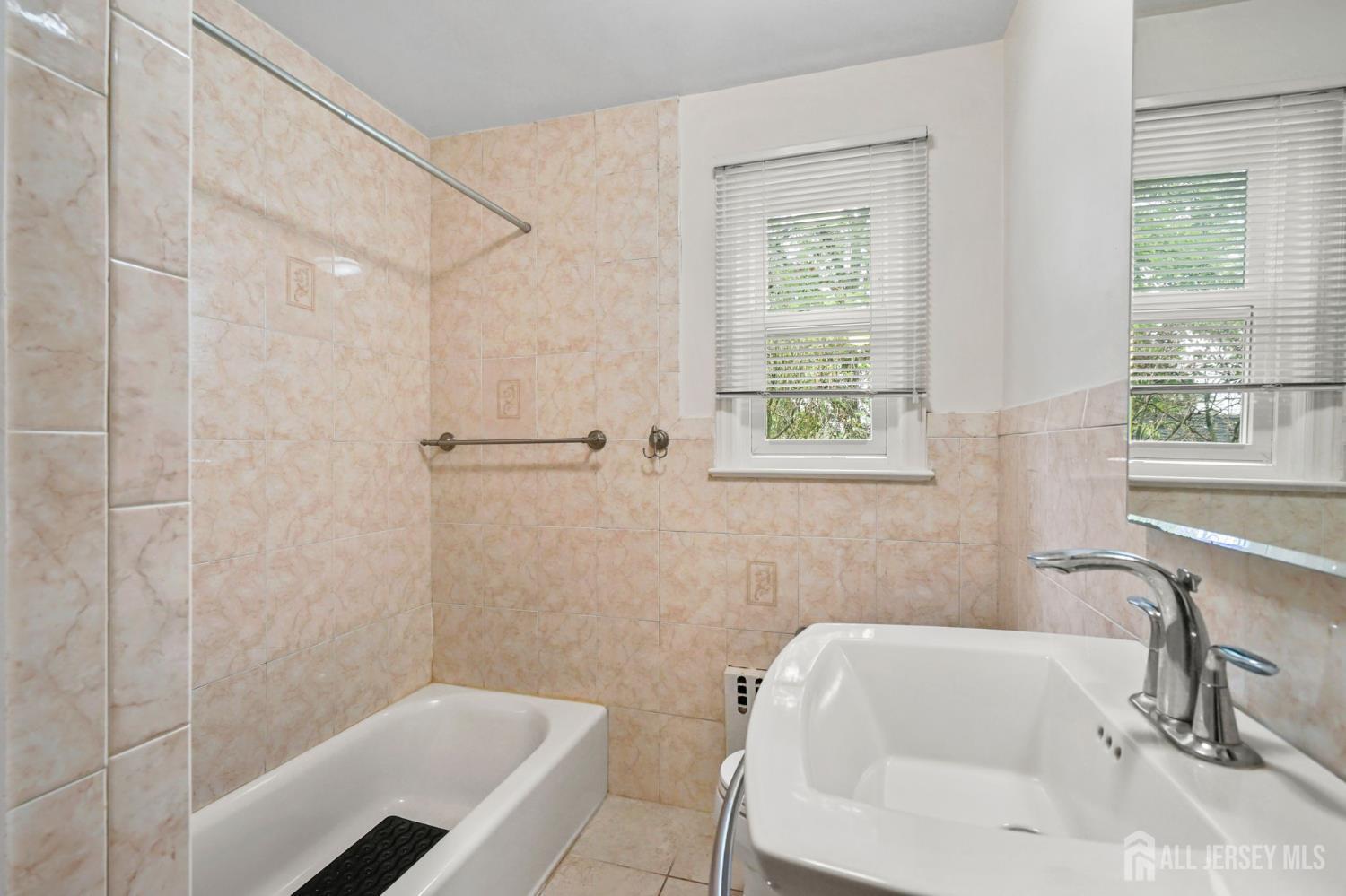 21 Reed Street Edison, NJ 08817 - Photo 11 of 27 a bathroom with a tub a sink and a window