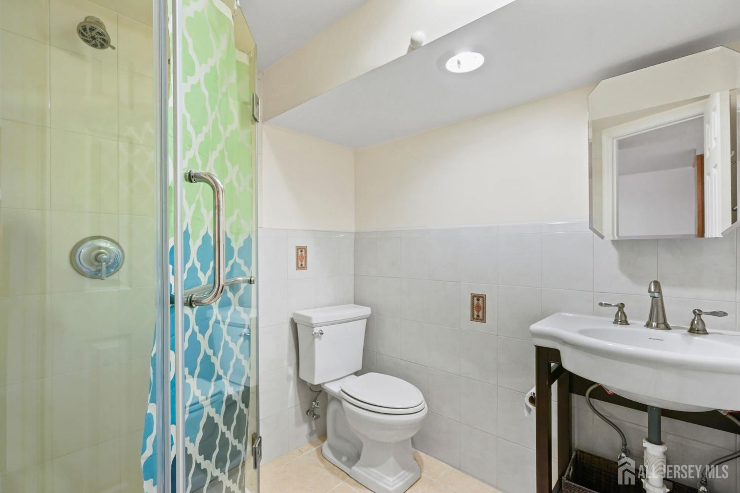 21 Reed Street Edison, NJ 08817 - Photo 24 of 27 a bathroom with a toilet a sink a shower and mirror