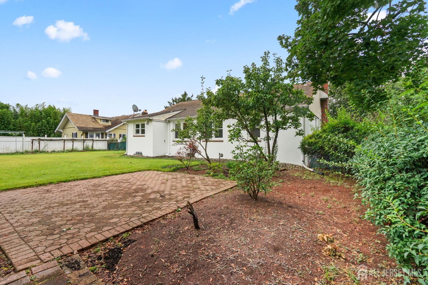 21 Reed Street Edison, NJ 08817 - Photo 25 of 27 a white house with a yard and plants