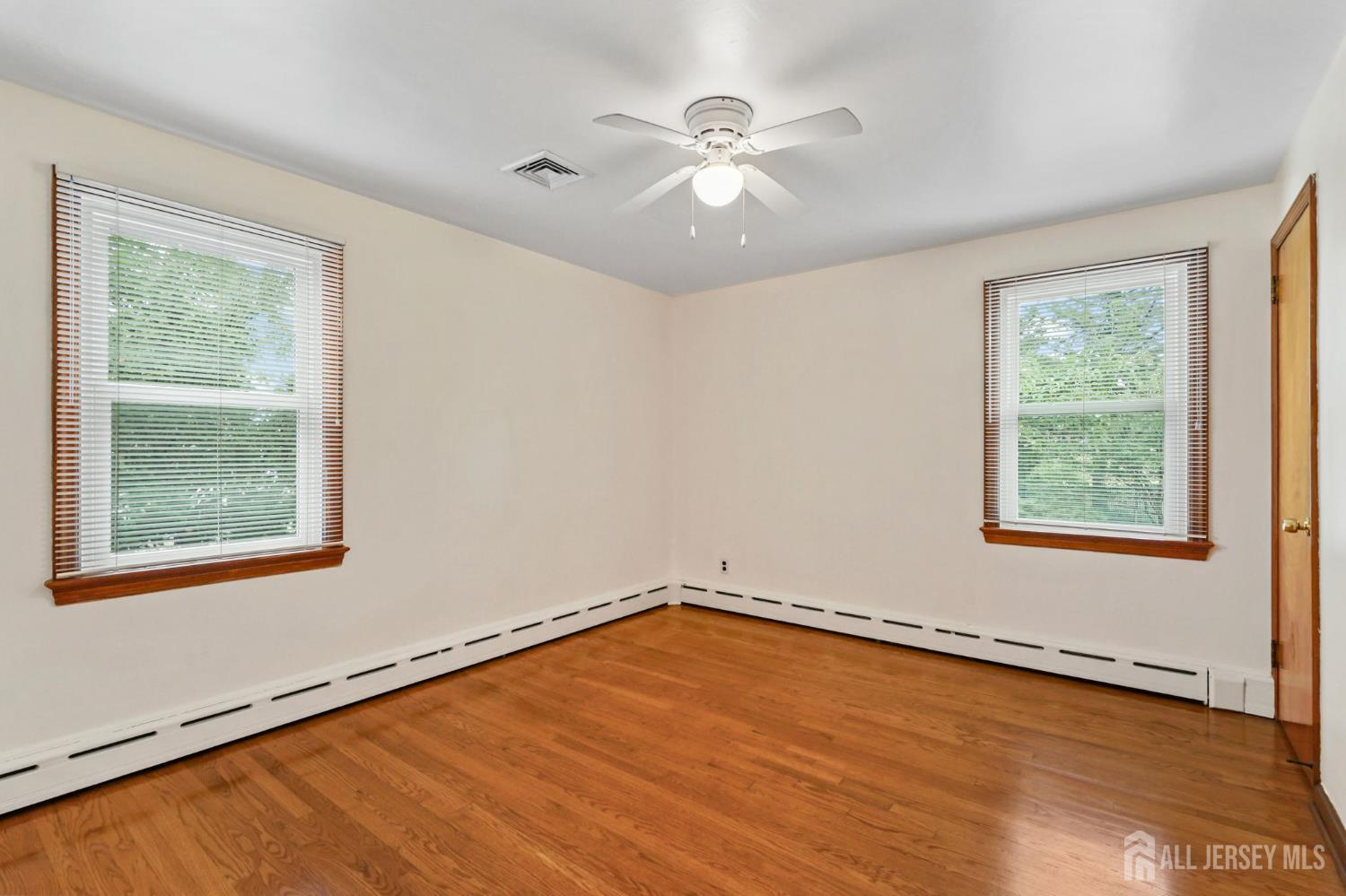 21 Reed Street Edison, NJ 08817 - Photo 9 of 27 a view of an empty room with a window and wooden floor