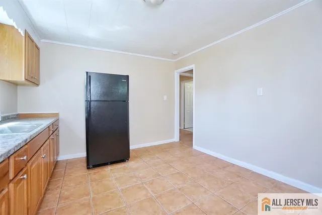 a view of kitchen with granite countertop cabinets and refrigerator