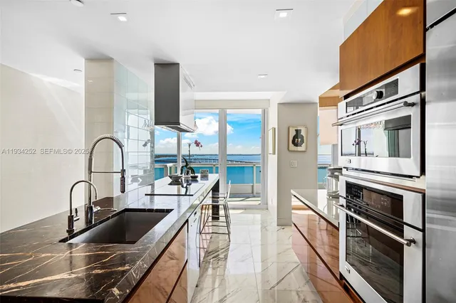 a kitchen with kitchen island a sink appliances and cabinets