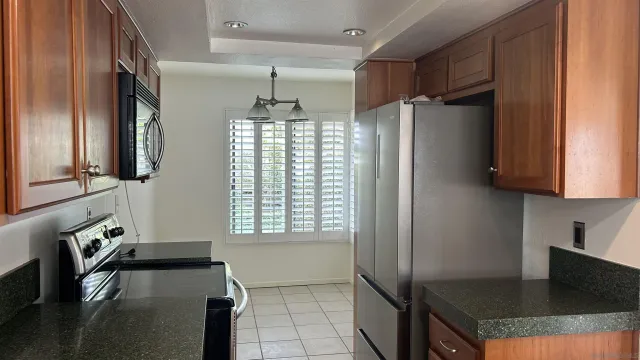 a kitchen with stainless steel appliances granite countertop a refrigerator a sink and a stove