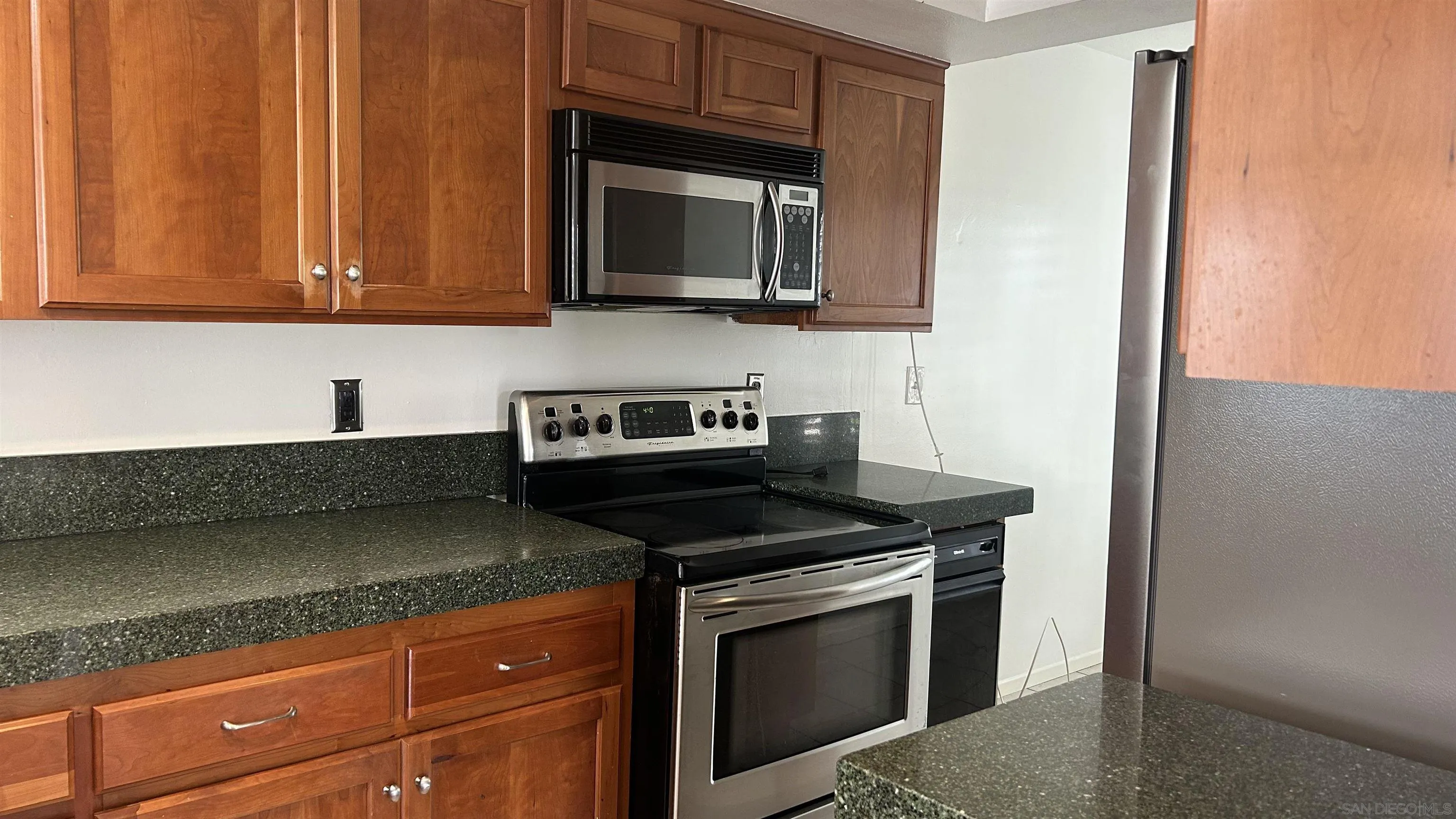 928 Intrepid Court Del Mar, CA 92014 - Photo 3 of 21 a kitchen with stainless steel appliances granite countertop a stove microwave and cabinets