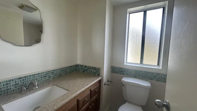a bathroom with a granite countertop sink and a mirror