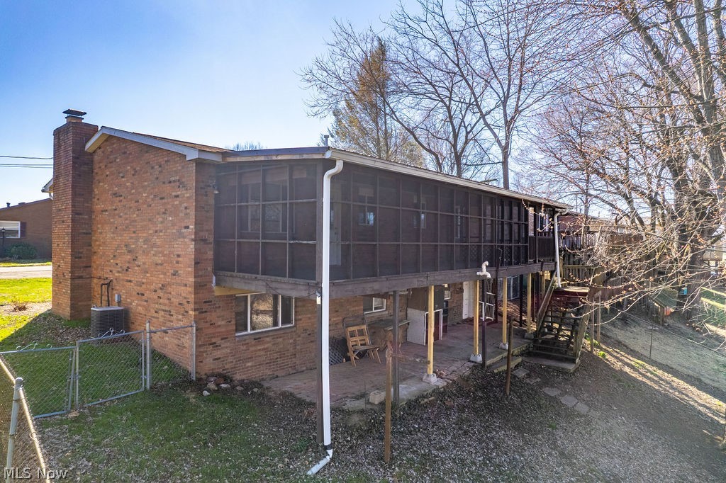 3601 River Road Vienna, WV 26105 - Photo 36 of 40 Back of house with a gate, a fenced backyard, brick siding, a chimney, and a patio area