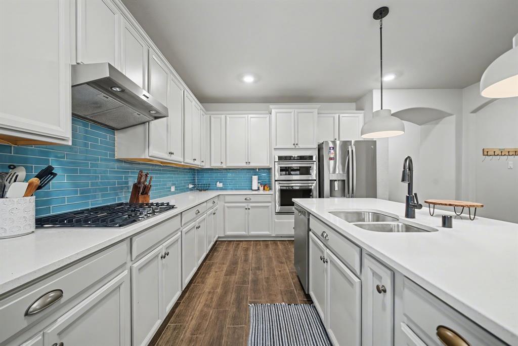 433 Forestridge Drive Fate, TX 75087 - Photo 17 of 38 a kitchen with stainless steel appliances granite countertop a sink a stove and a refrigerator
